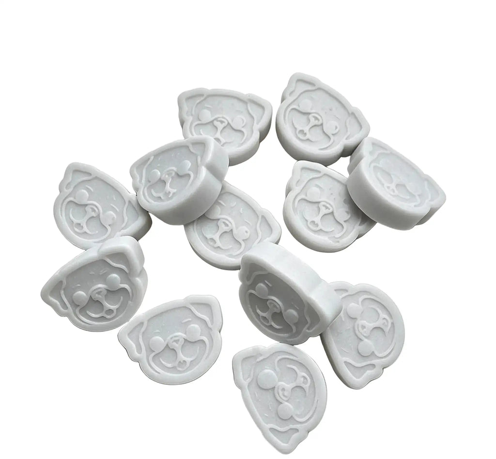 A set of white wax melts cutters shaped like cartoon dog faces, arranged on a plain white background.