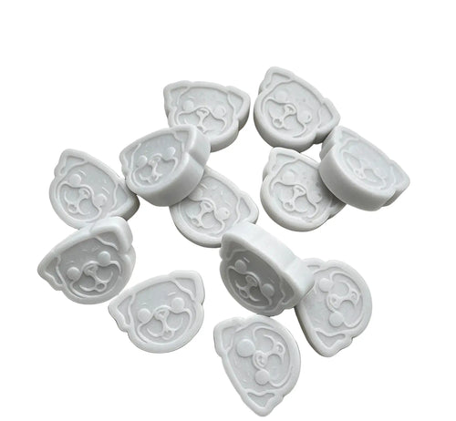 A set of white wax melts cutters shaped like cartoon dog faces, arranged on a plain white background.