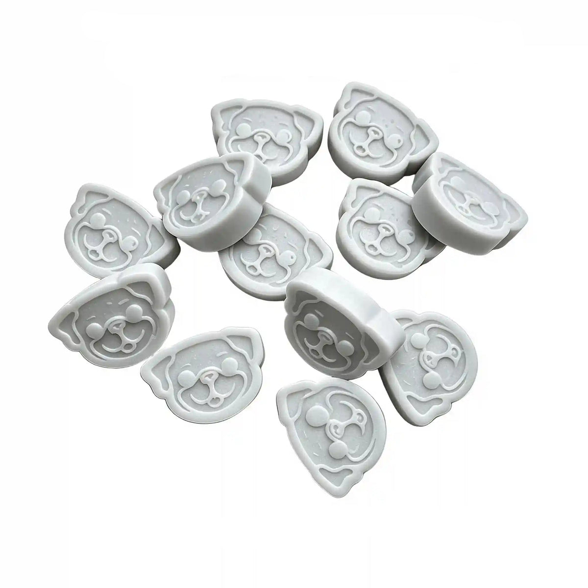 Twelve light gray pug-shaped wax melts arranged on a plain white background, with small descriptive text printed above them.