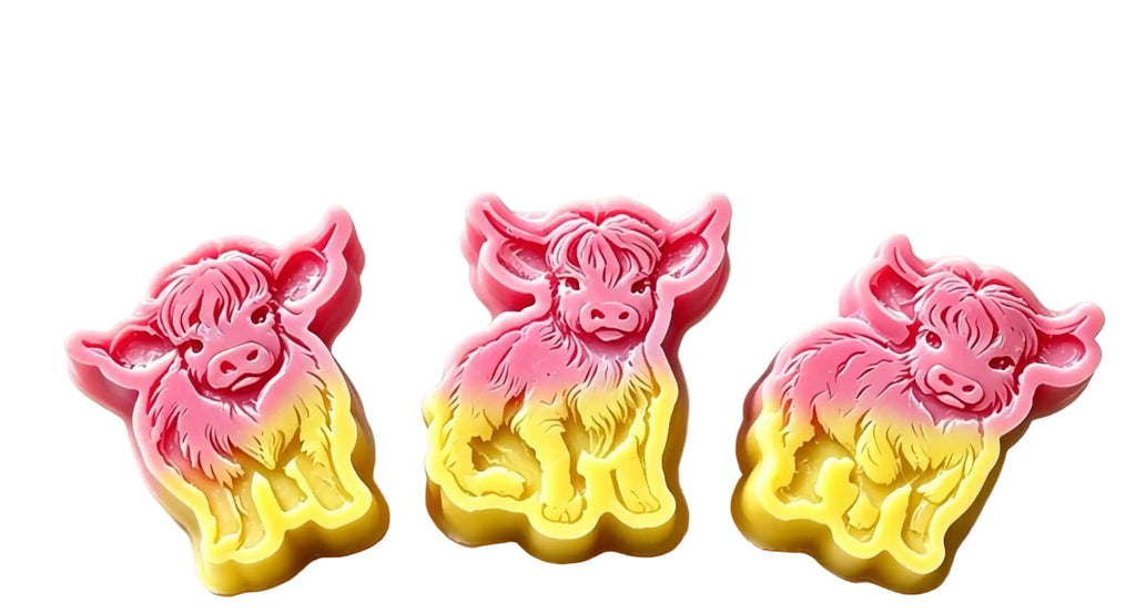 Three cow-shaped wax melts  in a pink-to-yellow gradient, displayed on a light floral background with descriptive text on the right.