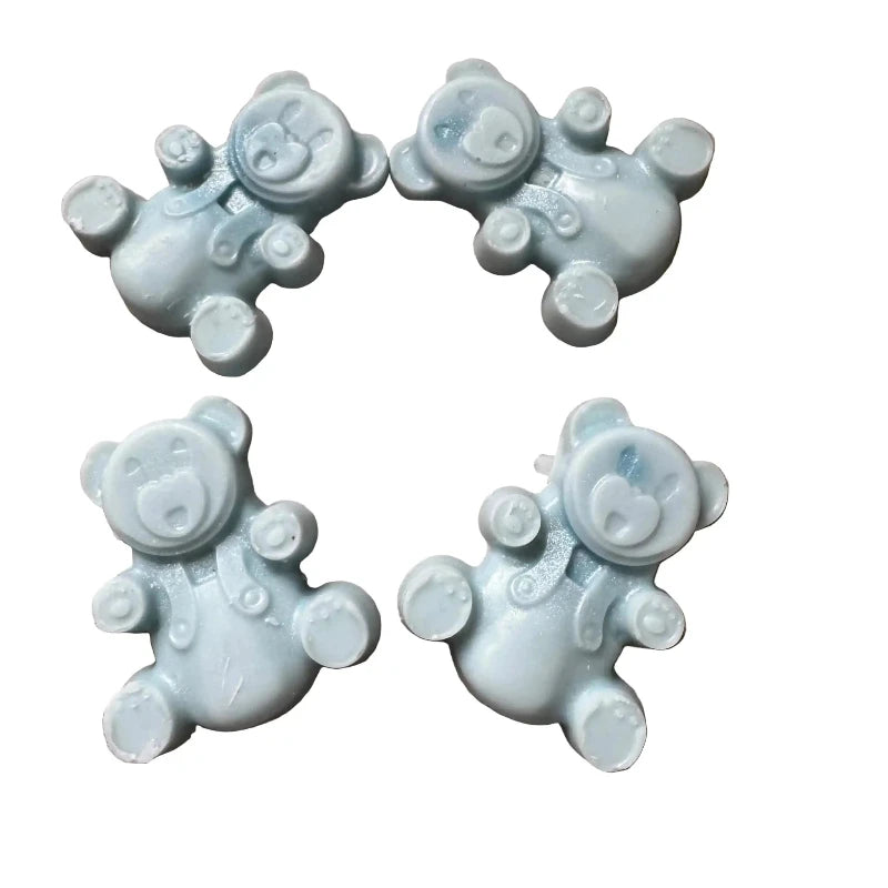 Four small pale blue teddy bear-shaped wax melts arranged in a 2x2 grid on a plain white background.