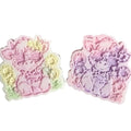 Two pastel-colored decorative highland cow shaped items with floral accents, shown on a plain white background. wax melt