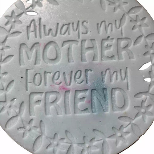 A round white decorative wax melt with embossed floral borders and the text 'Always my MOTHER Forever my FRIEND' in raised lettering.