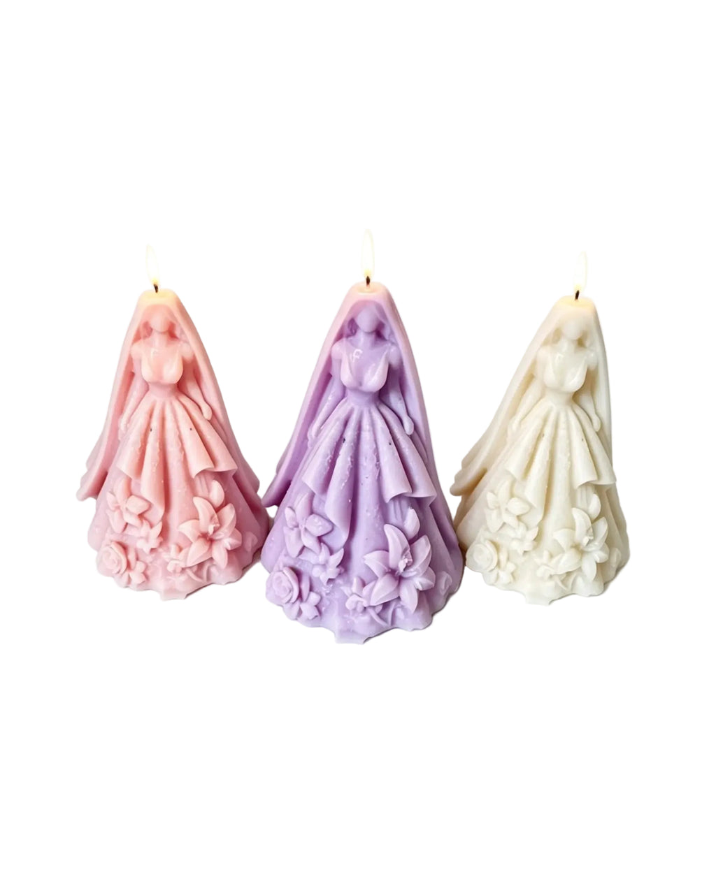 Three bride-themed taper candles with detailed wedding dresses and veils, shown in pink, lavender, and ivory on a white background.