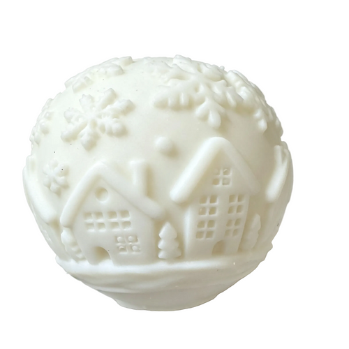 A white CANDLE featuring embossed winter motifs, including snowflakes, clouds, and small houses with snowy roofs, shown on a plain white background.