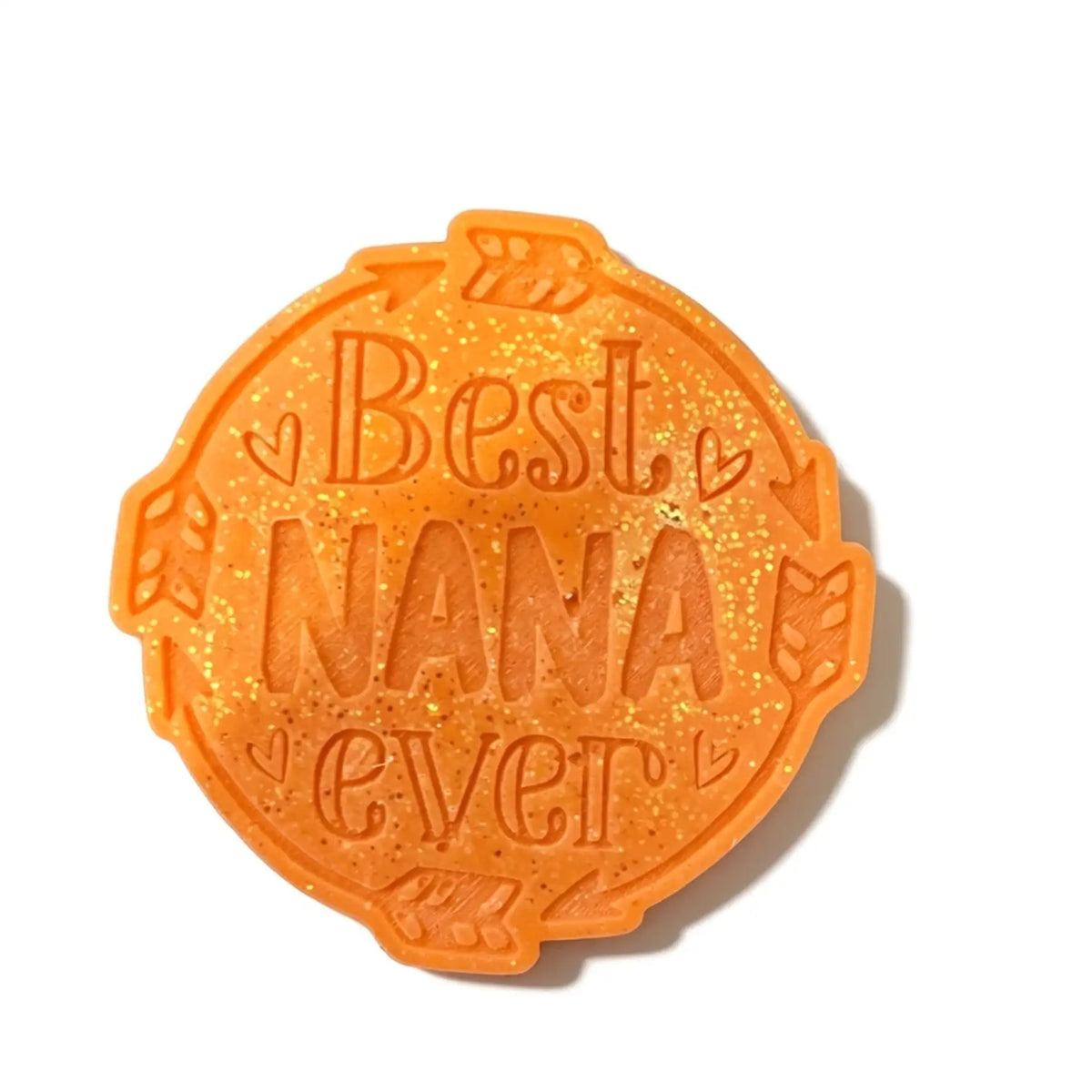 An orange glittery oval-shaped wax melt embossed with the words 'Best NANA ever' and small heart details, shown on a white background with a soft shadow.