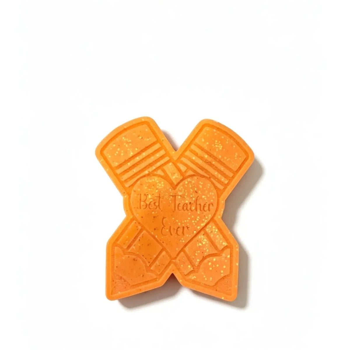 An orange glittery X-shaped teacher wax melt featuring crossed pencils and a central heart with the embossed text 'Best Teacher Ever', shown on a plain white background.