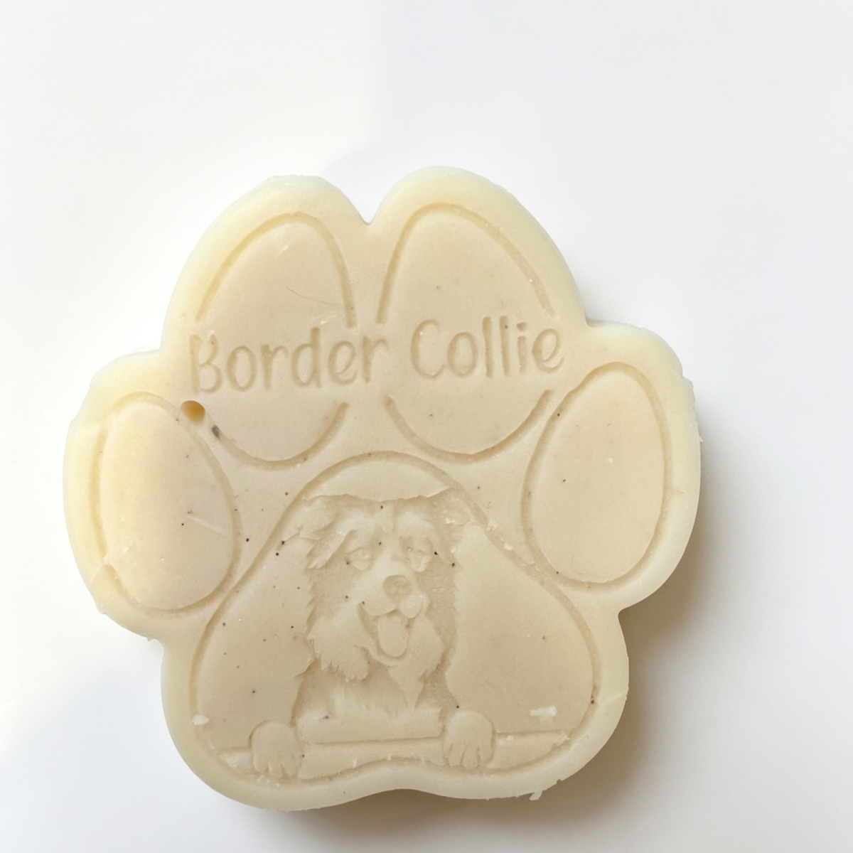 A paw-shaped Wax Melt with 'Border Collie' written on it and an embossed dog illustration, photographed on a plain white background.