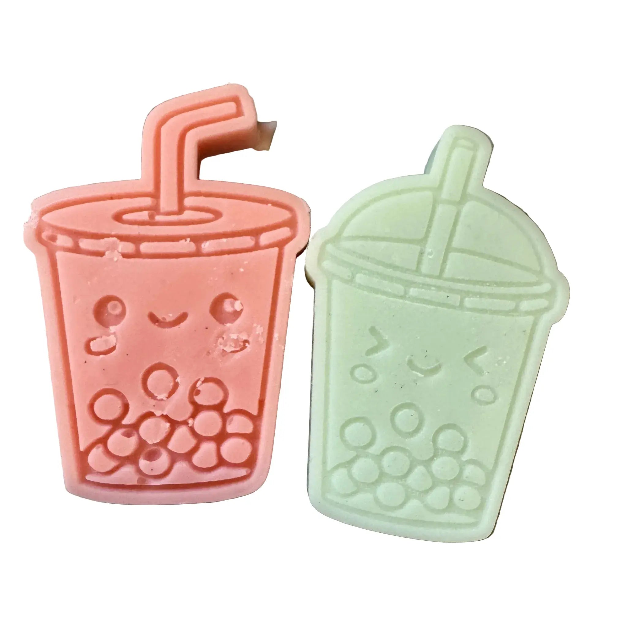 Two cute boba tea cup wax melts one in coral pink and one in mint green, shown side by side on a plain white background.