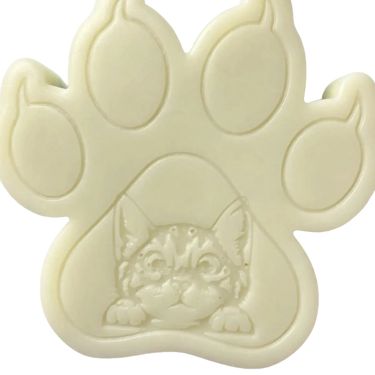 An off-white paw-shaped WAX MELT featuring an embossed kitten face in the center, shown against a plain white background.