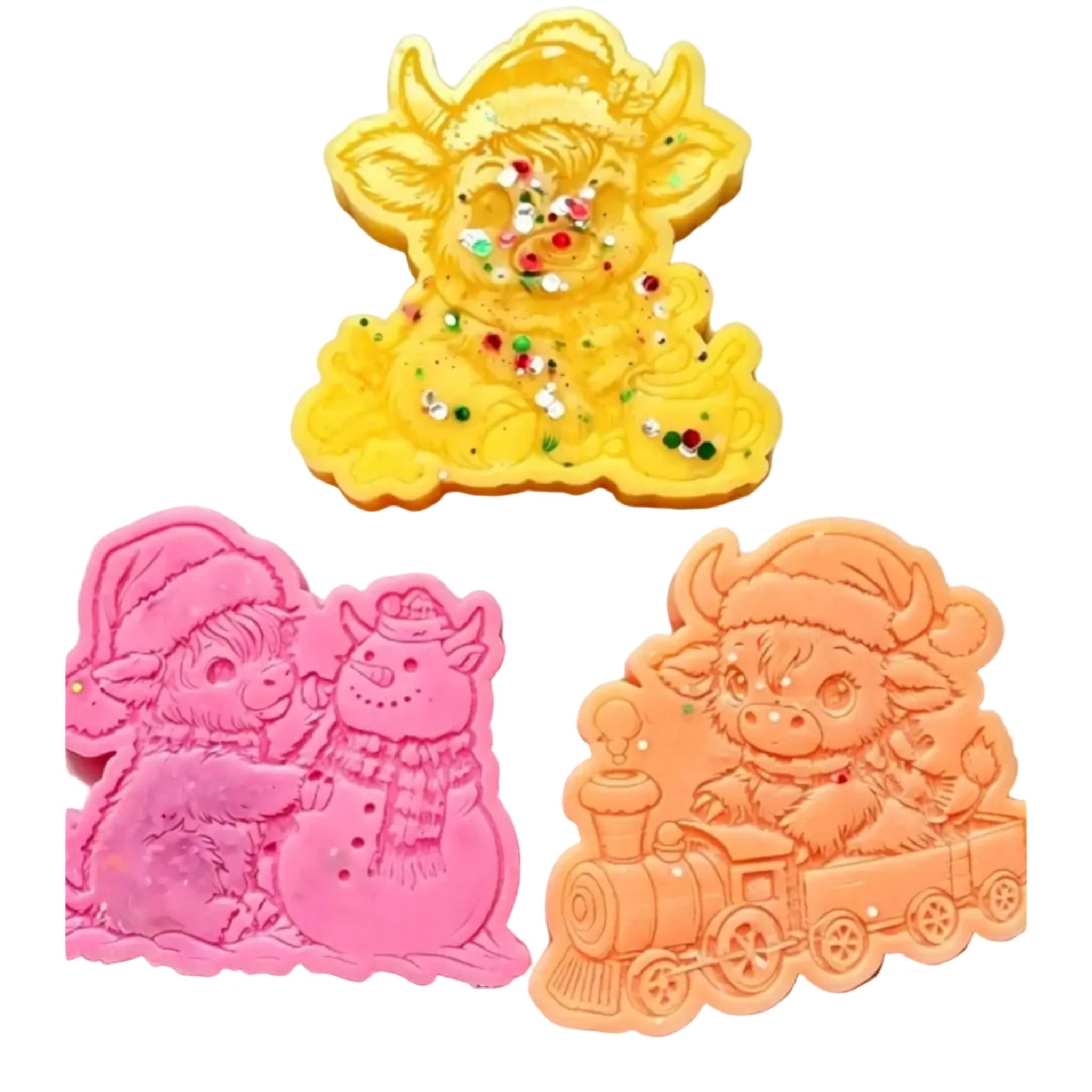 Three colorful, animal-shaped WAX MELTS s on a plain white background: a yellow cow with embedded glitter in the center, a pink snowman and rabbit motif on the lower left, and an orange train driver with a cow on the lower right. WAX MELTS 