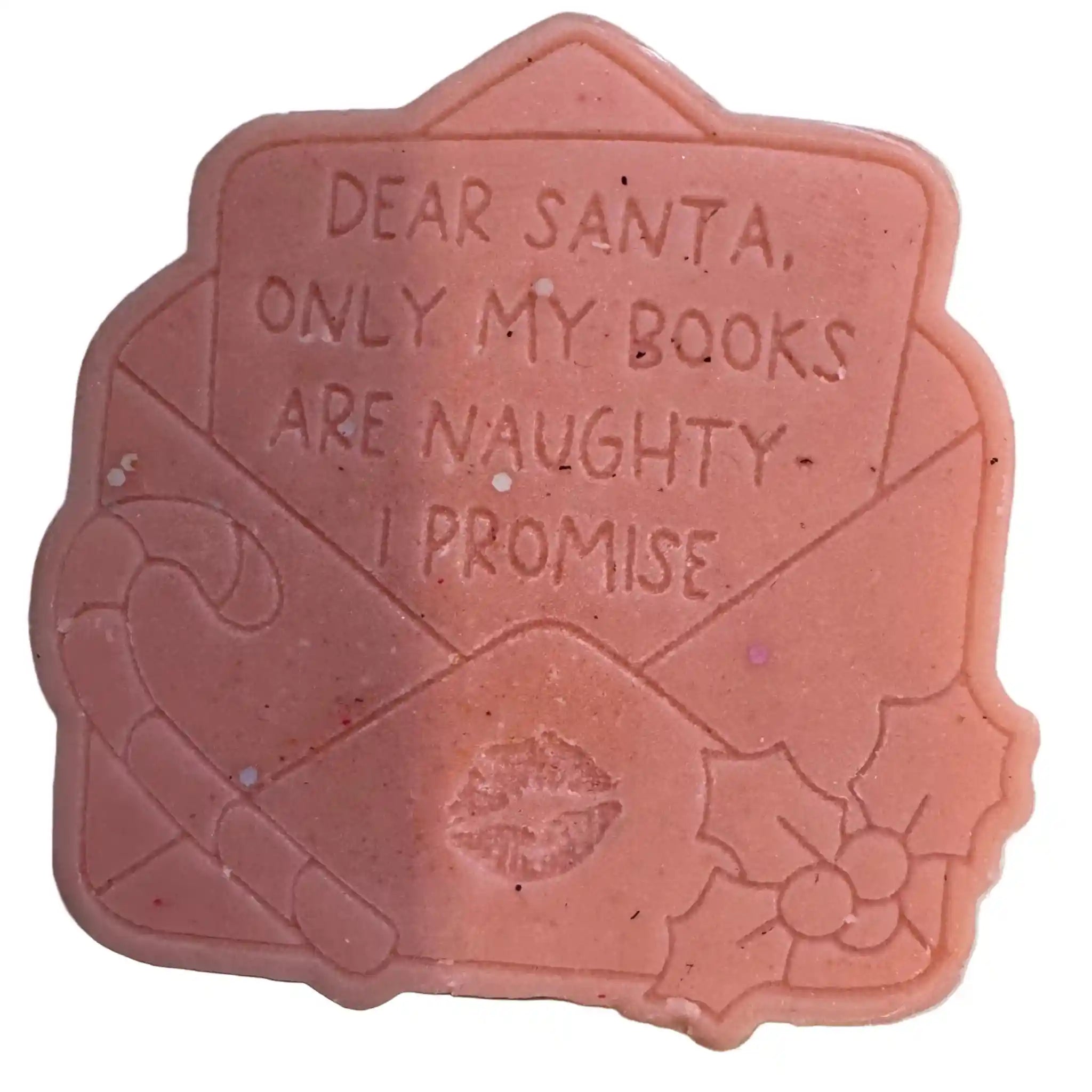 A novelty lip balm or wax seal shaped like a pink Christmas letter envelope, embossed with 'DEAR SANTA, ONLY MY BOOKS ARE NAUGHTY - I PROMISE' and decorated with a candy cane, holly, and a kiss mark.