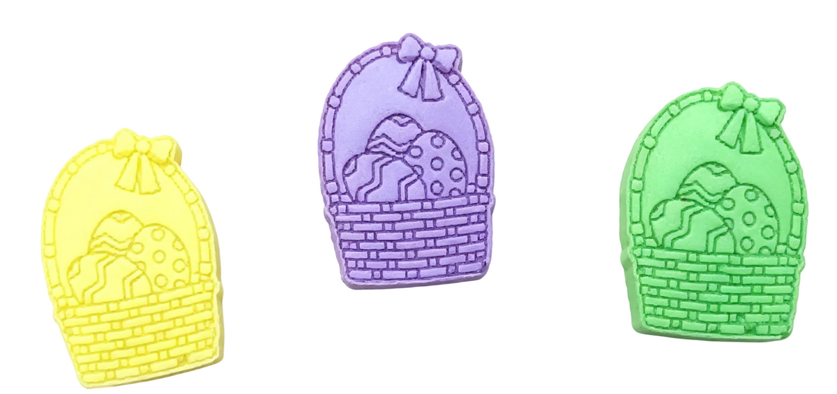 Three Easter basket-shaped wax melts side by side on a plain white background. The center item is purple and features a raised pattern of eggs inside the basket.