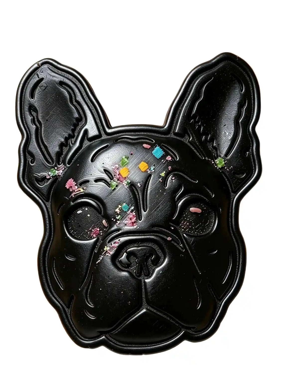 A black French Bulldog-shaped tray or mold decorated with colorful glitter and small flower-like embellishments, shown against a plain white background.