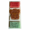 A rectangular white wax bar with three stacked colored sections: a pink top section embossed with 'MESSY HAIR', a brown cow-face center section, and a light green bottom section embossed with 'DON'T CARE'.