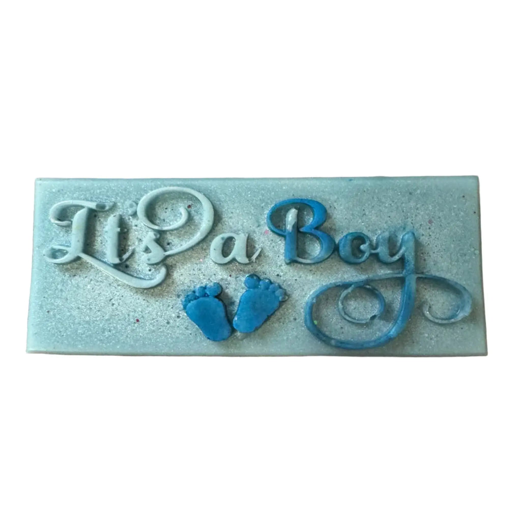 A rectangular light blue decorative plaque with embossed text reading 'It's a Boy' in white and blue, plus two small blue baby footprints, shown on a plain white background. wax melt