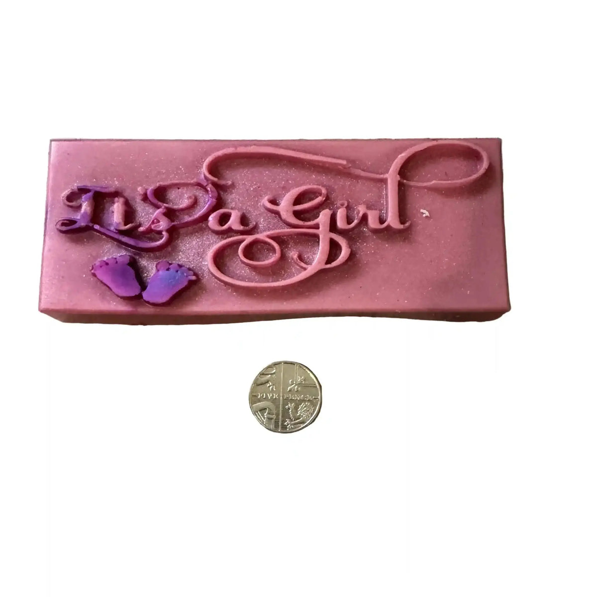 A pink rectangular soap bar with the words 'No a Girl' in raised cursive script and small purple baby footprints, shown on a white background with a coin below for scale. wax melt snap bar