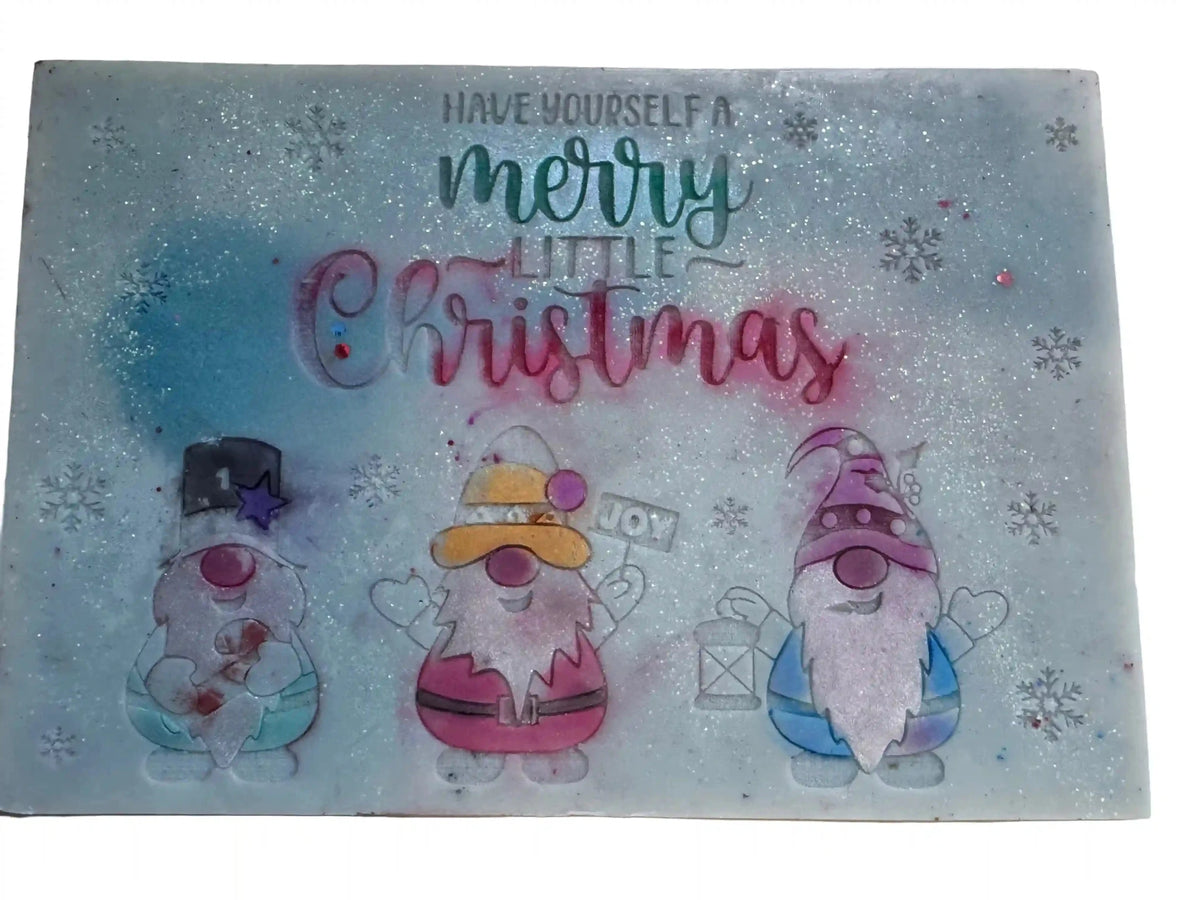 A rectangular Christmas-themedsmash bar large 'HAVE YOURSELF A merry Little Christmas' in stylized lettering, decorated with three cartoon garden gnomes and silver glitter flecks on a pale blue background.