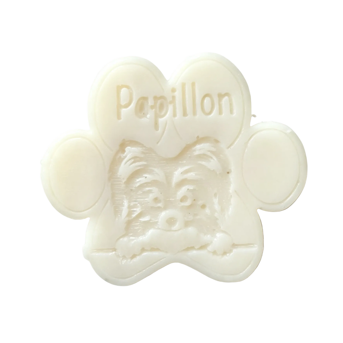 A white paw-shaped wax melt  featuring an embossed dog face and the word 'Papillon' on a heart-shaped section, photographed on a plain white background.