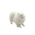 A small white CANDLE FIgurine of a fluffy dog, likely a Pomeranian, shown on a plain white background.