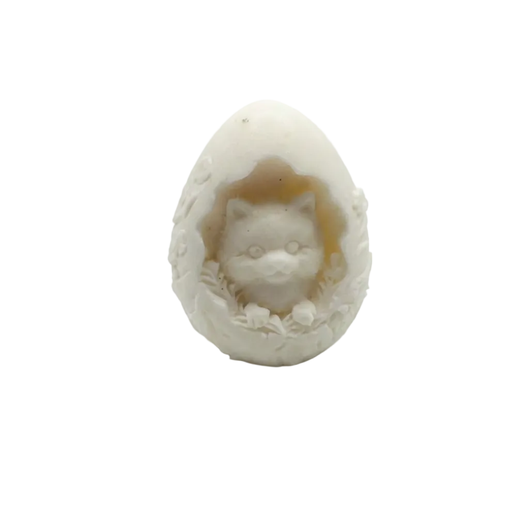 A small carved  CANDLE figurine of a cat peeking out of an egg, made from a warm off-white stone or resin, set against a plain light gray background.