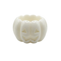 A white pumpkin-shaped  candle holding made of wax with a carved jack-o'-lantern face, photographed on a seamless white background.