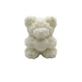 A small white teddy bear candle with a textured, crystalline or frosted surface, centered on a seamless light gray background.