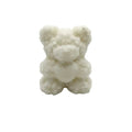 A small white ROSES WAX CANDLE or sugar-glass teddy bear figurine with a rough, textured surface, centered on a plain white background.