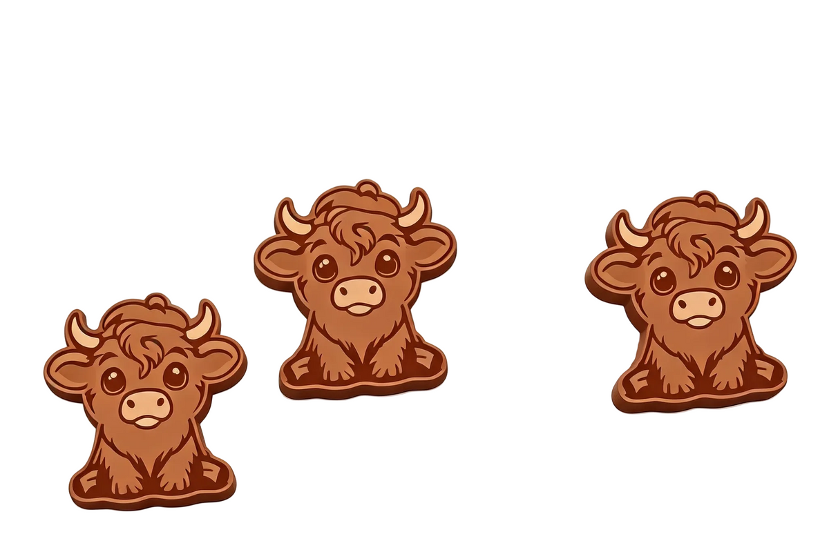 Three cartoon-style brown cow wax melts or charms arranged on a plain white background.