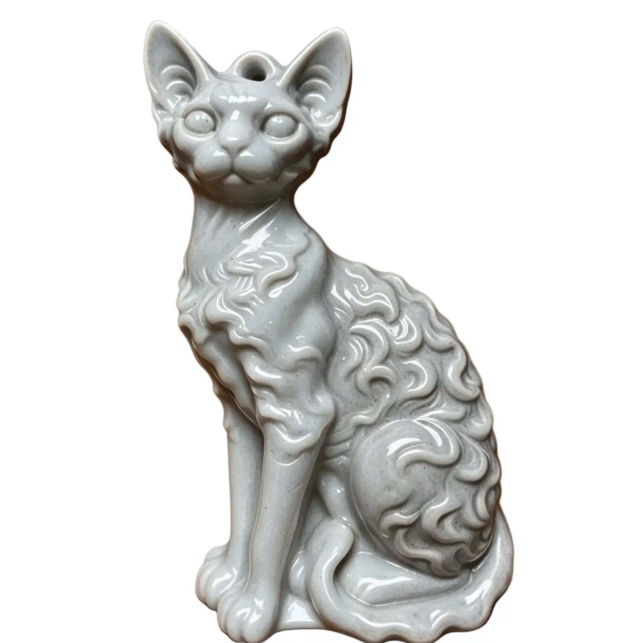 A white ceramic figurine of a curly-haired cat, shown sitting and facing forward against a plain white background. wax melt