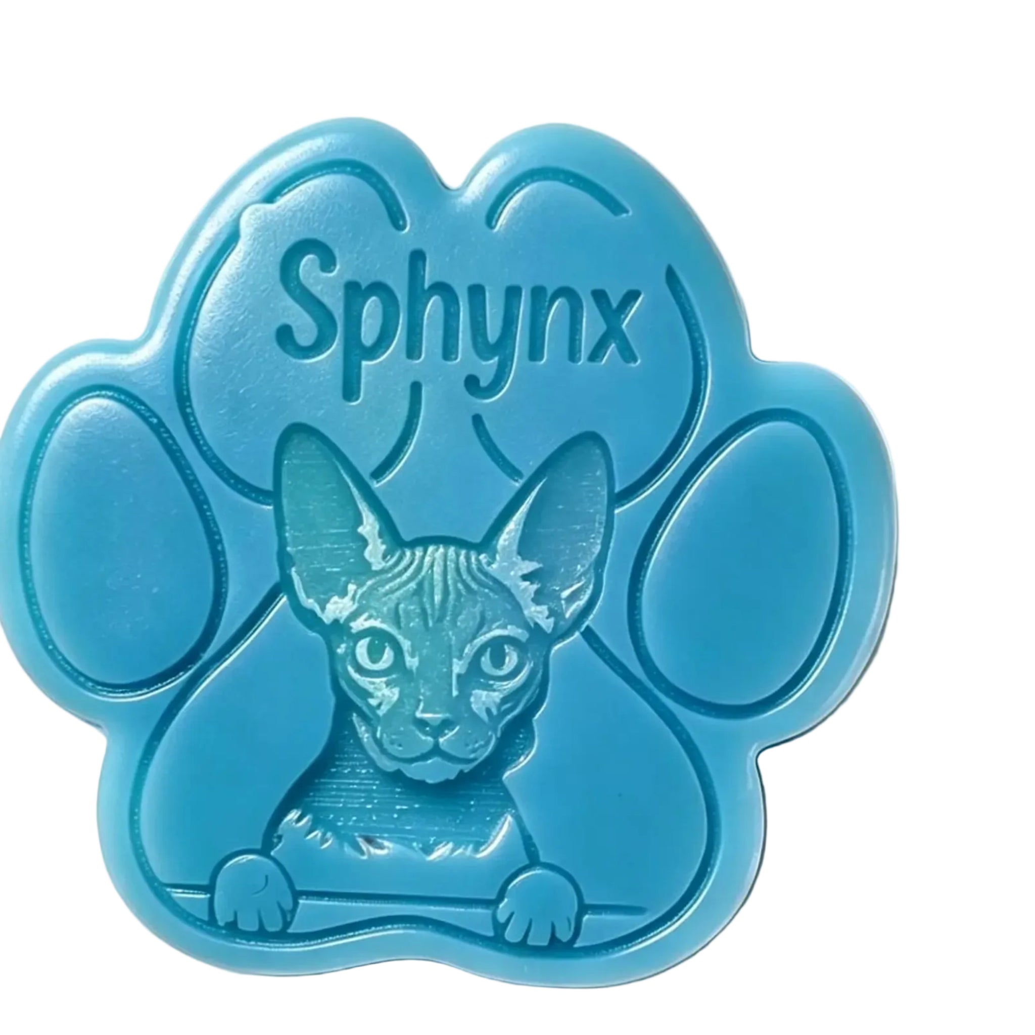 A blue paw-shaped WAX MELT featuring an embossed Sphynx cat face and the word 'Sphynx' on the top, photographed on a plain white background.
