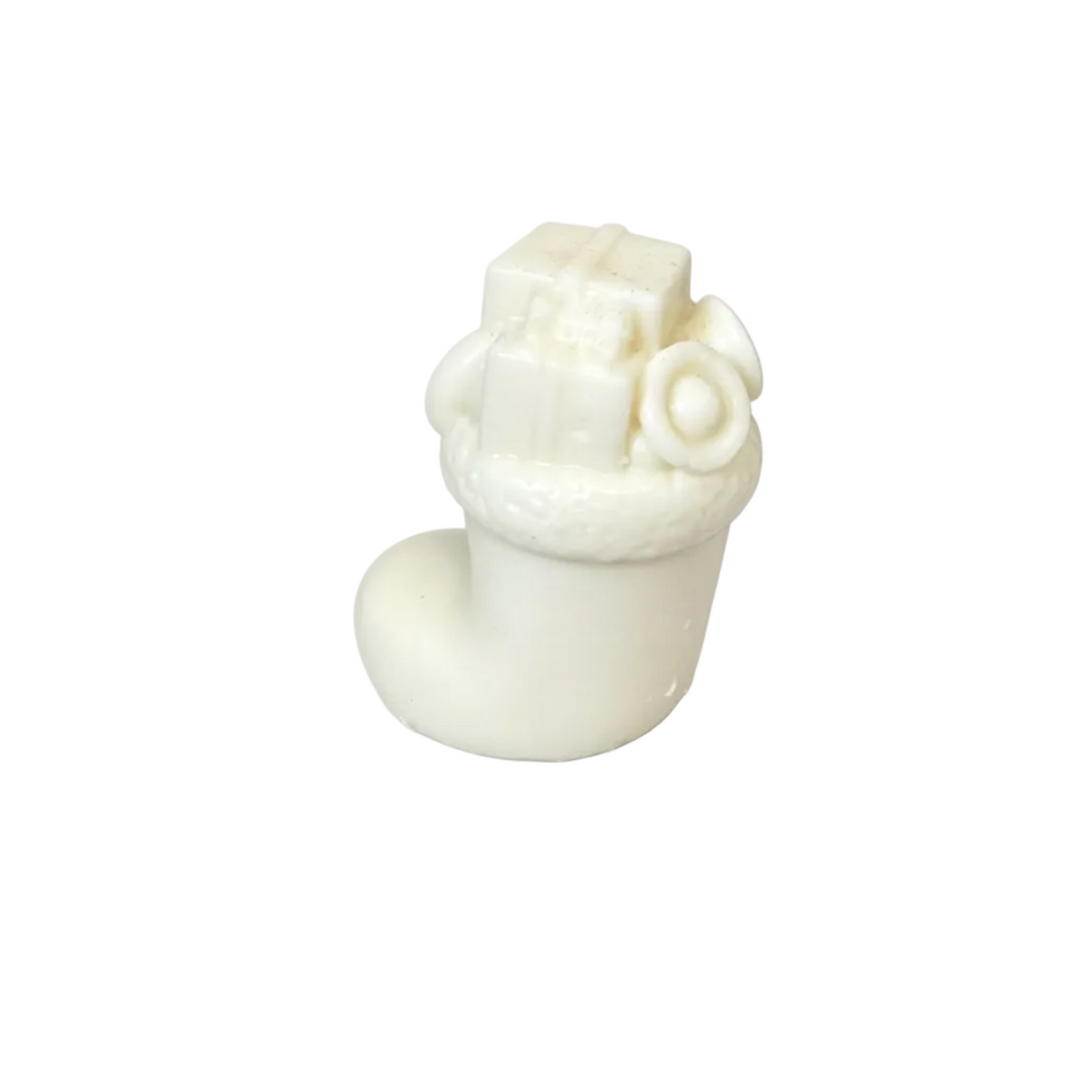 A small white CANDLE haped like a stocking or boot with a gift box and wrapped ornament on top, photographed on a clean white background.
