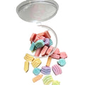 A clear plastic cup tipped over on a white surface,
like animals and flowers in soft pastel colors including pink, blue, green, yellow, and lavender. scoopies wax melts 