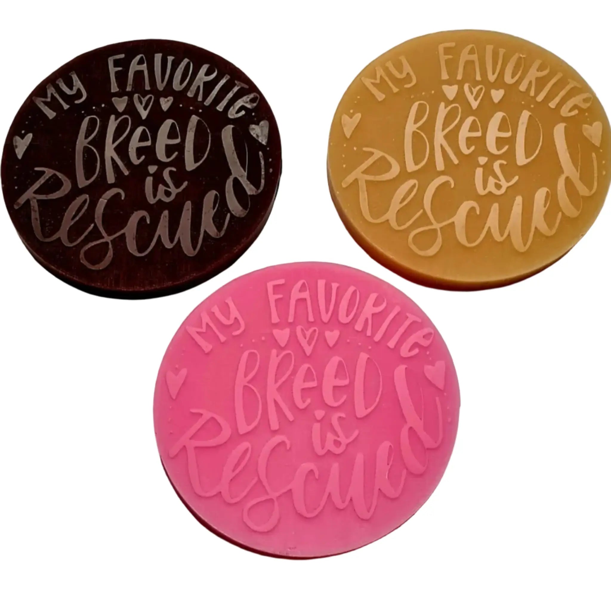 Three round decorative WAX MELTS with the phrase 'My Favorite Breed is Rescued' in raised script, shown in dark brown, tan, and pink on a white background.