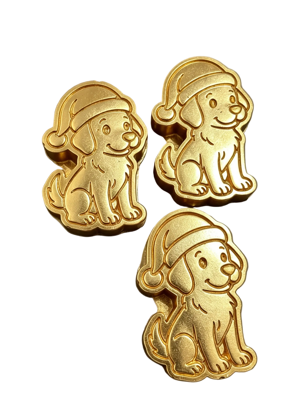 Three gold-colored dog-shaped wax melts wearing Santa hats, arranged on a dark gray background.