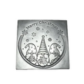 A square silver-toned metal Christmas wax melt featuring an engraved design of three gnomes under stars and snowflakes, with the text 'Merry Christmas' at the top, shown on a white checkered background.