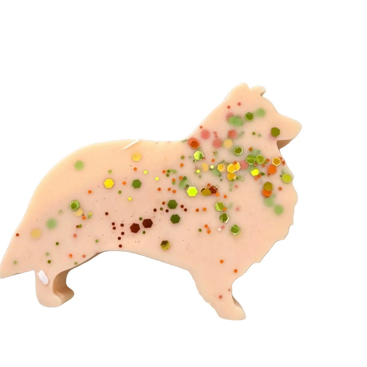 A dog-shaped WAX MELT in a pale peach-beige color, decorated with multicolored glitter and small confetti, shown on a plain white background.