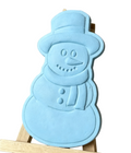 A light blue snowman-shaped decorative wax melt  displayed on a small wooden easel against a neutral indoor background.